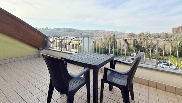 A balcony with a table and chairs, a view of the countryside, and a metal railing. - N036 - Numana, two-room apartment with terrace in residence with swimming pool (Maratta)