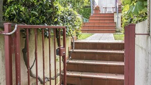 Una entrada protegida por una reja con una escalera exterior que conduce a un edificio.