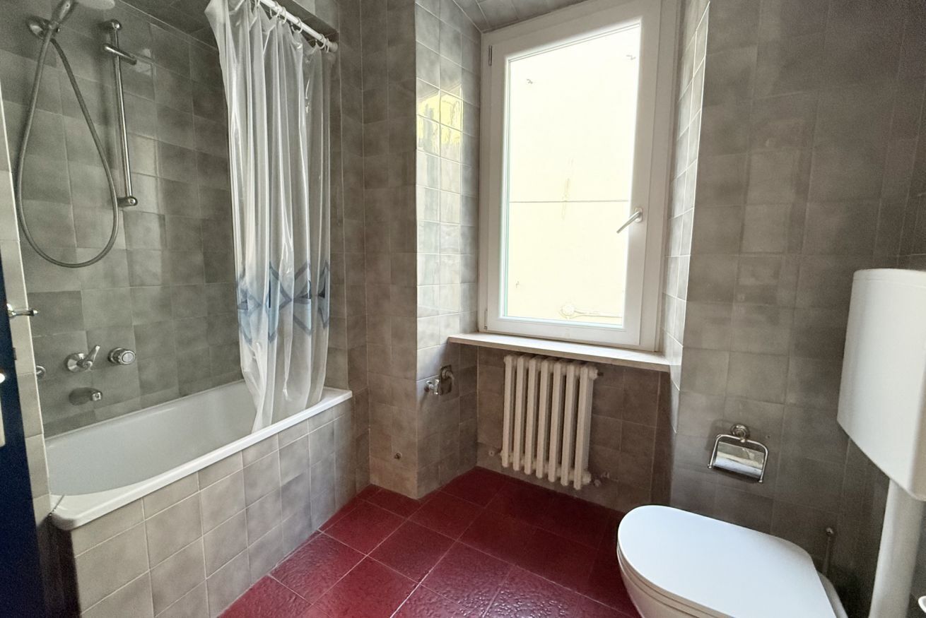 Un baño con bañera, inodoro, ventana y ducha.