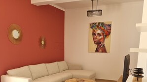 A modern living room with a beige sofa, a round coffee table, and a pink ottoman. - 4 bedroom villa with private pool, 5 min from the beach, Wifi included (Moncarapacho)