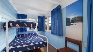 A bunk bed room with a window, a chair, and a wall painting. - Berry, 16 East Street (Crescent Head)