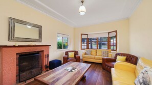 A living room with a fireplace, a sofa set, a coffee table, and a large window with a view.