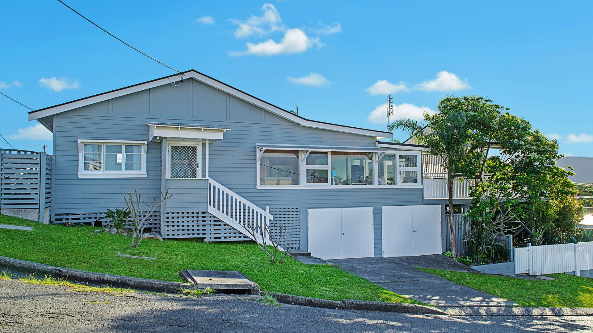 A single-story house with a front porch, a small staircase, and a garage.