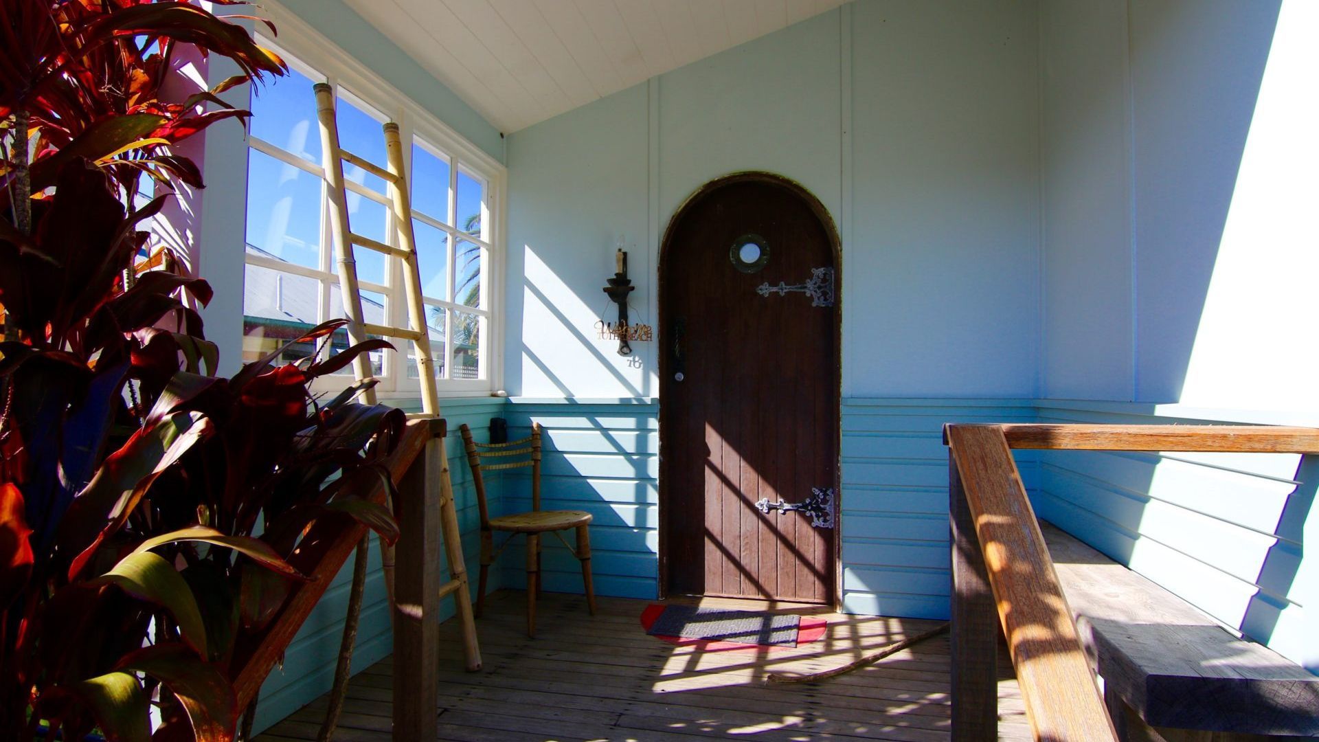 A room with a wooden door, a window, and a chair.