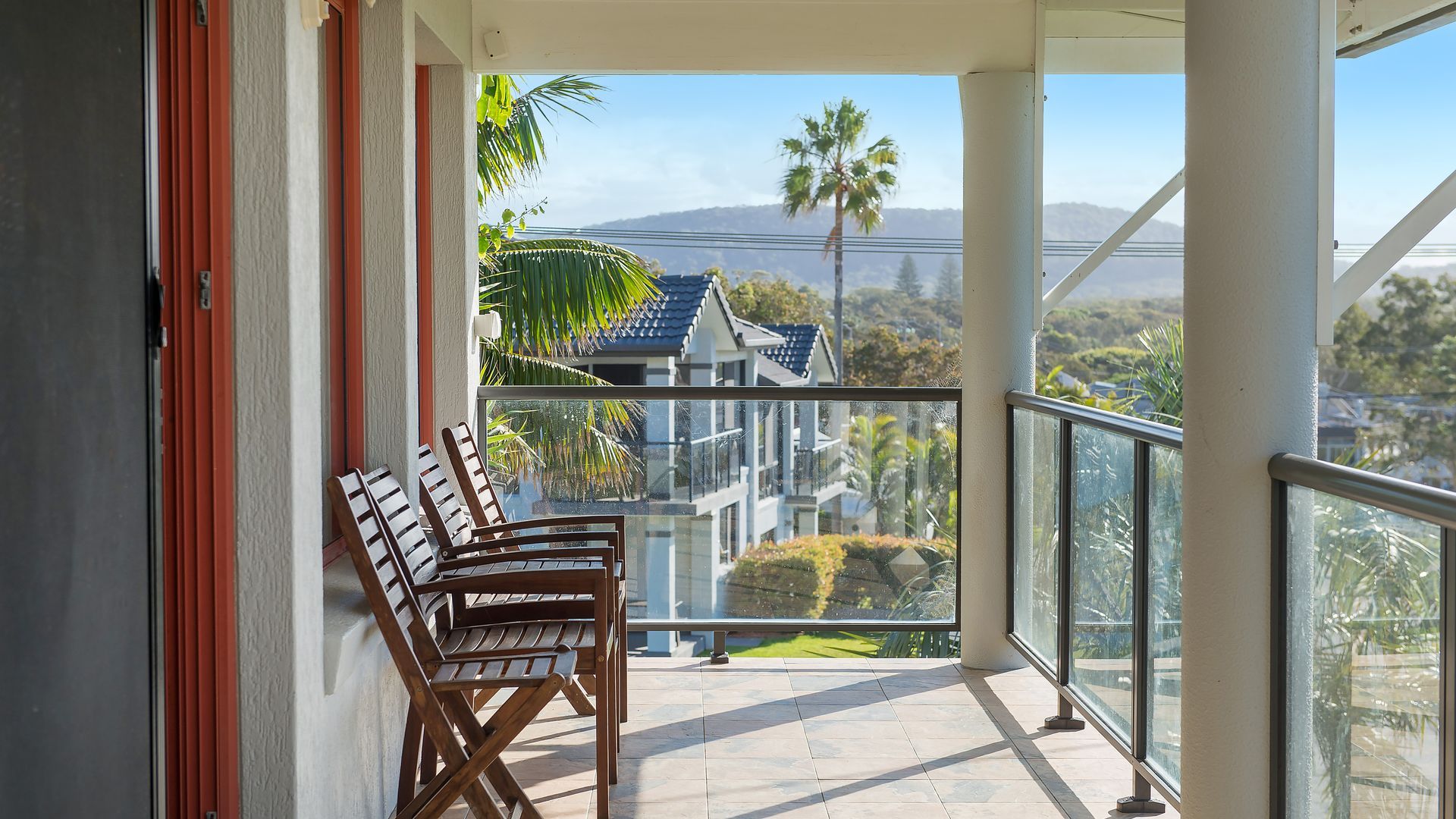 A balcony with a view of houses and mountains.