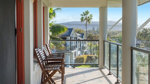 A balcony with a view of houses and mountains.