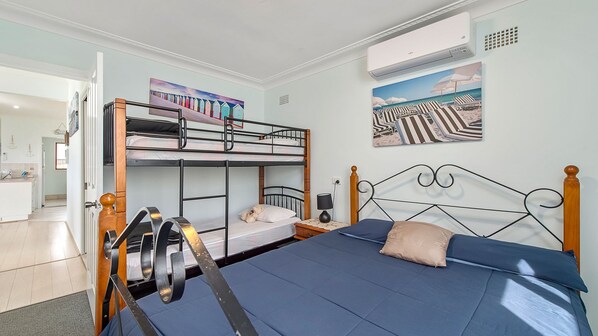 A bunk bed room with a single bed, a desk, and a chair.