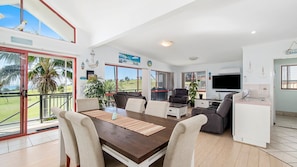 A spacious living area with a dining table, sofas, and a TV. - Heathers Seaside Apartments 2, 10 Rankine Street (Crescent Head)