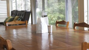 Una mesa de madera con una bolsa de papel blanca y un vaso estampado.
