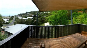 A wooden deck with a view of a residential area and greenery.