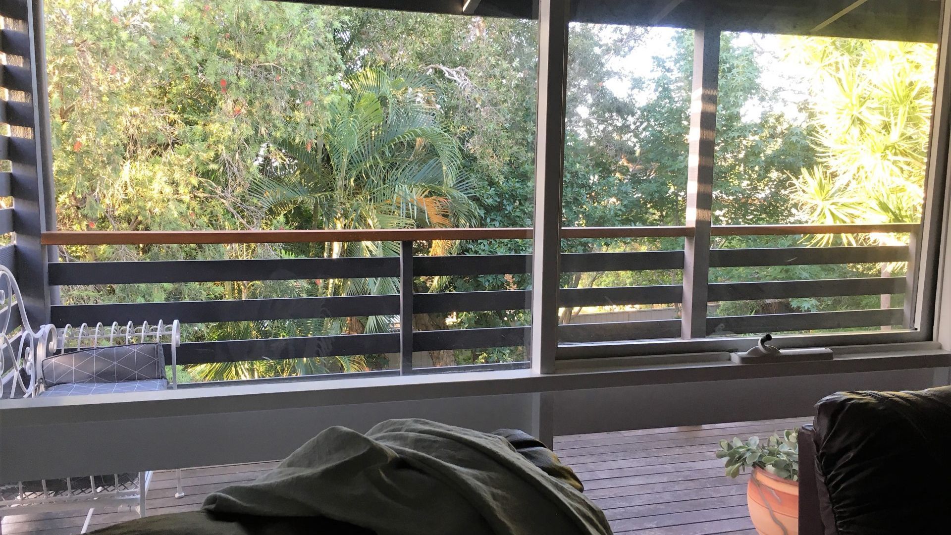 Een kamer met een raam dat uitkijkt op een tuin.