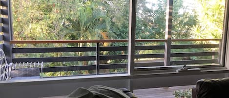 Een kamer met een raam dat uitkijkt op een tuin.
