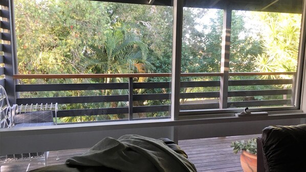 A room with a window overlooking a garden.