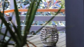 A wicker basket with a handle on a balcony railing.
