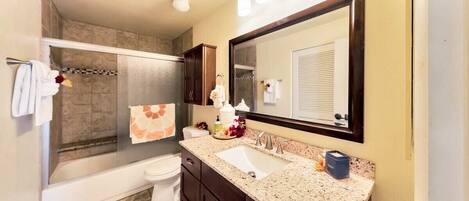 A bathroom with a shower, toilet, and sink.