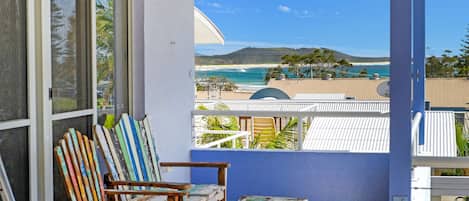A balcony with a view of a beach and ocean.