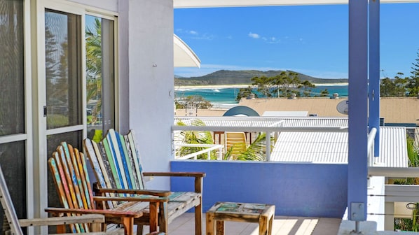 A balcony with a view of a beach and ocean.