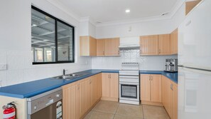 A modern kitchen with a dishwasher, oven, and a coffee maker.