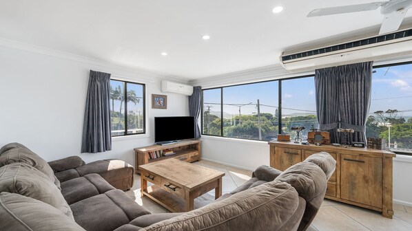 A living room with a flat-screen TV, a wooden coffee table, and a sofa.