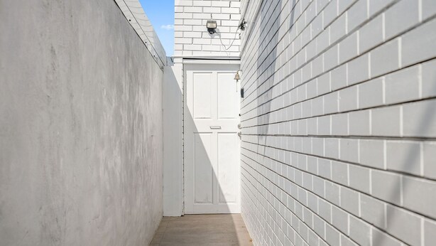 A narrow corridor with a white door at the end, flanked by white brick walls. - Bombora, 3/4 East Street (Crescent Head)