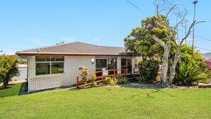 A single-story house with a tiled roof, a brick exterior, and a front porch. - Beachcomber, 27 Dulconghi Street (Crescent Head)