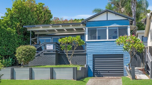 A two-story house with a blue exterior, a covered porch, and a garage. - Sea Salt, 24 Stewart Street (Crescent Head)