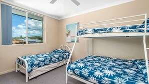 A room with bunk beds, a window with a view, and a painting on the wall. - Maliblue, 5/1 Main Street, Crescent Head (Crescent Head)