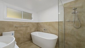 Ein Badezimmer mit Badewanne, Toilette und Duschbereich.