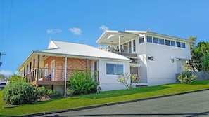 A two-story house with a covered porch and a fenced yard.