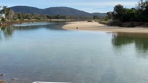 A river with a sandy beach and a person paddling. - Fleur Cottage, 7 Willow Street (Crescent Head)