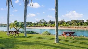 Un espacio para picnic con bancos y vistas a la playa y al agua.
