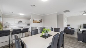 A modern apartment with a dining area, kitchen, and living space.
