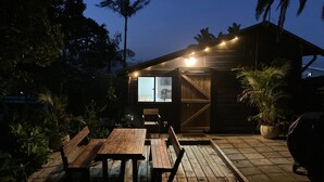 A wooden cabin with a deck, a table, and benches. - The Tree House, 6 Gowing Street (Crescent Head)
