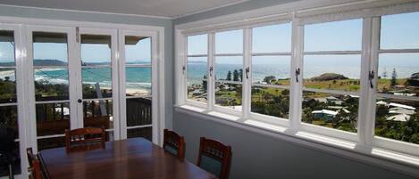 A dining area with a view of the ocean and a residential area.