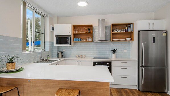 A modern kitchen with a stainless steel refrigerator, a microwave, and a dishwasher.