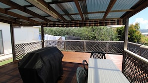 An outdoor patio with a covered area, a grill, and a table. - Horizons 7 East Street, Crescent Head (Crescent Head)