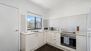 Cocina compacta con microondas, tostadora, hervidor y horno.