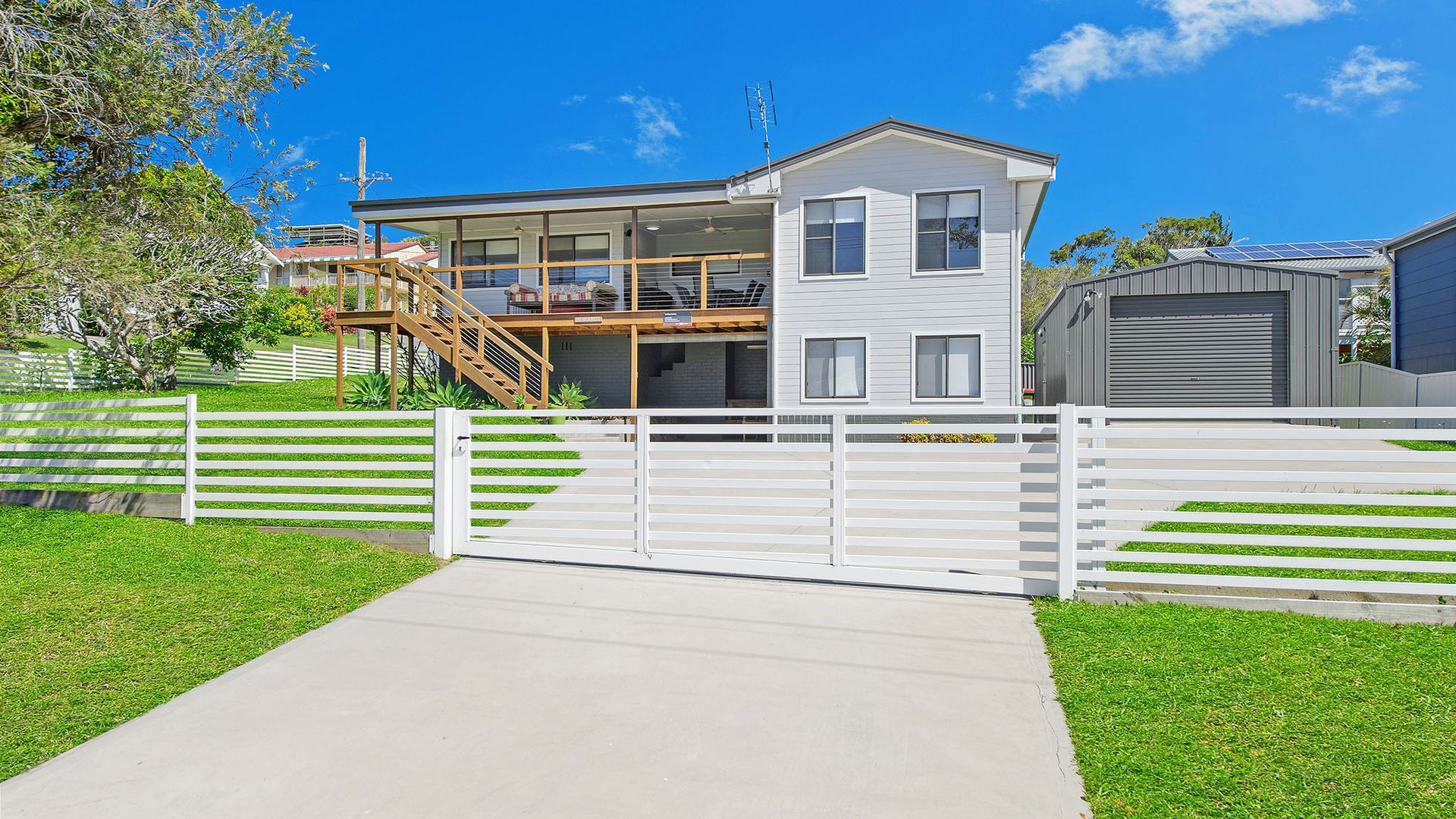 A two-story house with a covered porch, a garage, and a fenced yard.