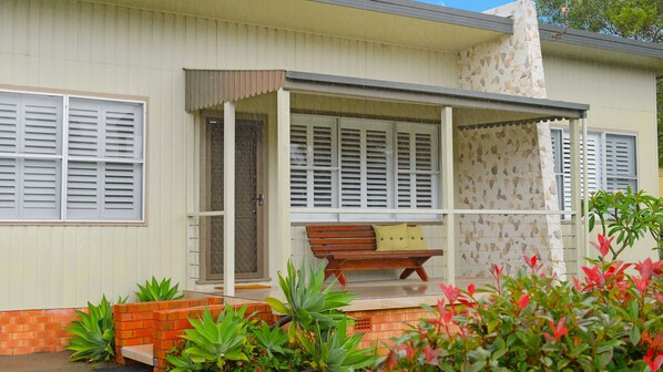 A house with a covered porch, a brick planter, and a bench. - Ondine, 4 Belmore Street (CRESCENT HEAD)