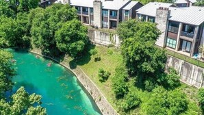 Un moderno resort con varias construcciones, una piscina y abundante vegetación.