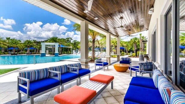 A covered outdoor area with seating and a pool.