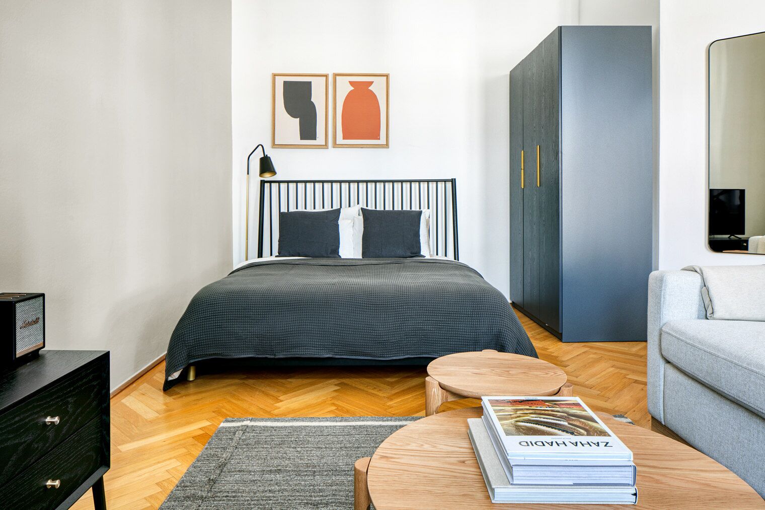 Une chambre moderne avec un lit, une table de chevet et une petite table ronde sur laquelle repose un livre.