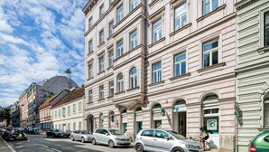 A row of classic European-style buildings with uniform facades and large windows.