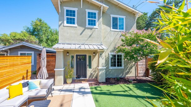 A two-story house with a front porch, a small garden, and a patio with outdoor furniture. - Swanky Downtown Cowboy (Paso Robles)