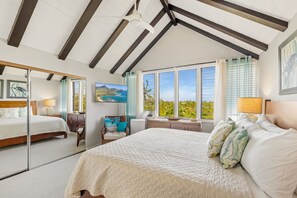 A bedroom with a large bed, a ceiling fan, and a view of the outdoors. - Makanui 522 – Mountain Views & PBAC Access (Koloa)