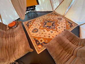Ein Zimmer mit zwei gepolsterten Sesseln, einem gemusterten Teppich und einem Tisch mit Stühlen.