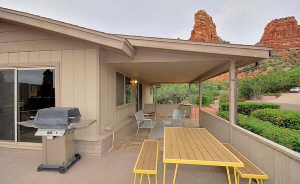 A covered patio with a grill, outdoor seating, and a view of red rock formations. - Bohemian Rhapsody Retreat ~ 2 Bed 3 Bath With Game and Theatre Room (Sedona)