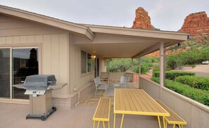 A covered patio with a grill, outdoor seating, and a view of red rock formations. - Bohemian Rhapsody Retreat ~ 2 Bed 3 Bath With Game and Theatre Room (Sedona)