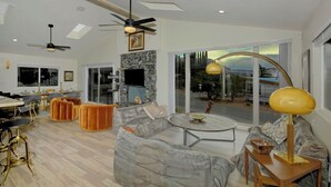 A modern living room with a sofa, coffee table, and dining area.