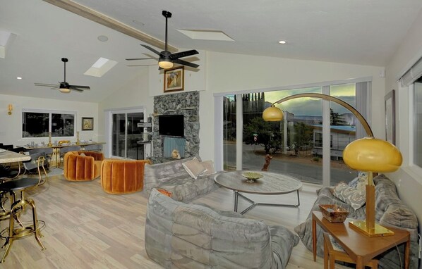 A modern living room with a sofa, coffee table, and dining area. - Bohemian Rhapsody Retreat ~ 2 Bed 3 Bath With Game and Theatre Room (Sedona)